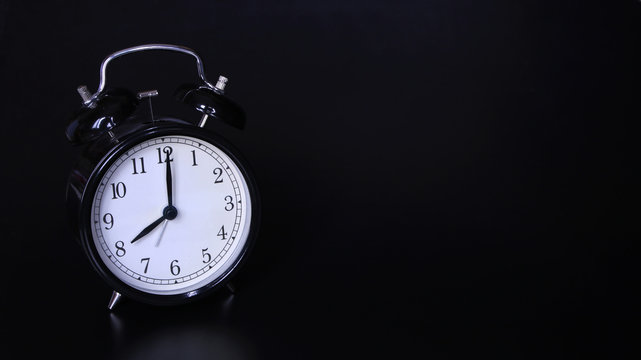 Close up image of old black vintage alarm clock. Eight o'clock