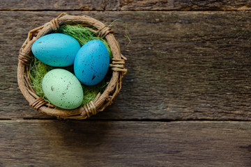 Easter eggs in a basket on a wooden background