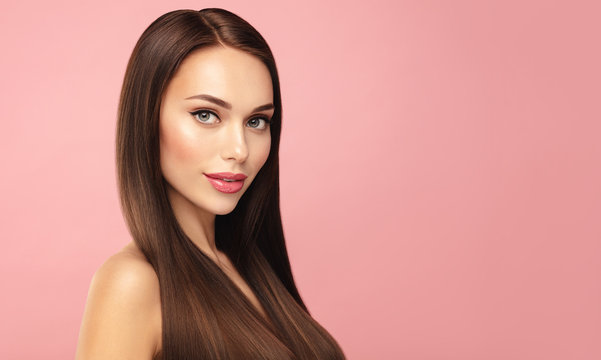 Beautiful Brown hair model face portrait. Elegant attractive woman with pergect skin and natural make up against pink bacground. Beauty salin and cosmetics concept. Banner with copy space.