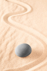 Fototapeta na wymiar Raked sand and spa wellness healing stones. Zen buddhism meditation stone for concentration and relaxation through minimalism and purity. Spiritual background with copy space.