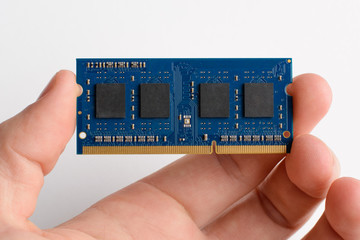 DDR memory card in man`s hand against white background. Upgrading laptop by adding module of RAM...