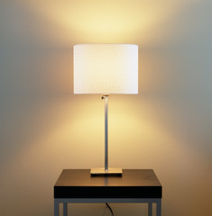 Lamp on table with painted wall background. Home energy use, electric lighting fixtures and...
