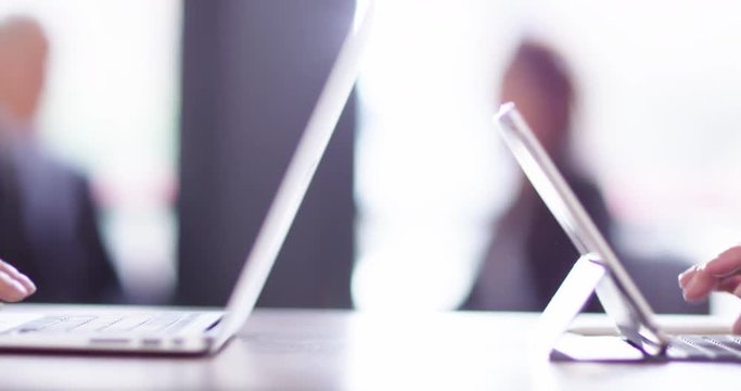 4K Panning shot with focus pull from businesswoman talking to hands typing on laptop