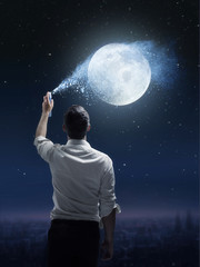 Conceptual portrait of a man sprinkling a moon