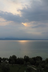 The sun breaking through the clouds over lake Garda Italy