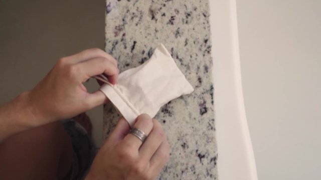 high angle of woman's hands preparing to put eco-friendly tampon in the bathroom