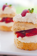 Homemade scones with strawberries and cream, side view close up