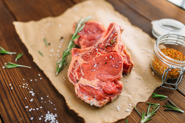 Uncooked meat in seasoning on wooden table