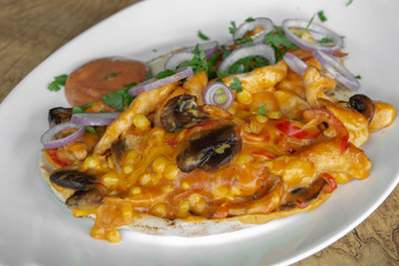 Faihita - spicy. Chicken fillet, mushrooms, roasted peppers, corn, Cheddar cheese, spicy sauce, parsley, red onion. Served on Arabic bread. Closeup