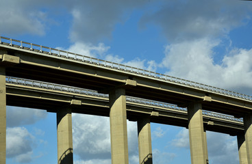 betonbrücke erstreckt sich vor blauem himmel mit wolken über das bild