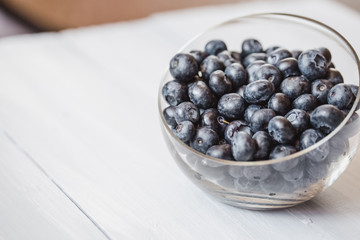 Plate with blueberries on a wooden table.