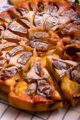 Food. Sweet pastries. Round cake with plums and thyme. Pictured with mint, wooden board and knife