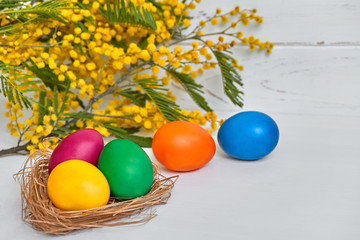 Colorful easter eggs with flowers on white wooden background Happy Easter concept