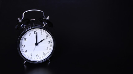 Close up image of old black vintage alarm clock. Two o'clock