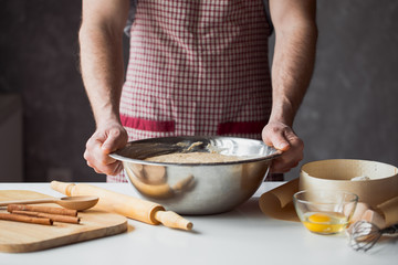 A handful of flour with egg on a rustic kitchen. Against the background of men's hands
