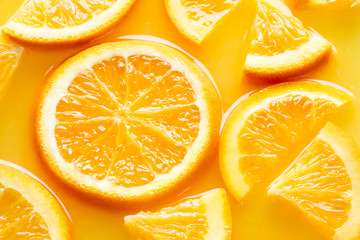 Plakat top view of orange slices in juice as background