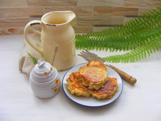 crepes pancakes with oak flakes on shabby wooden white background with rustic milk jug and silver cutlery