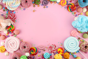 candies with jelly and sugar. colorful array of different childs sweets and treats on pink