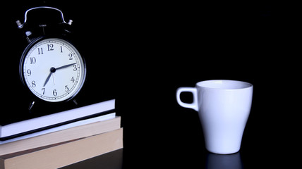 Naklejka premium Coffee for start to work. Table for work, books, clock on the table and cup of coffee