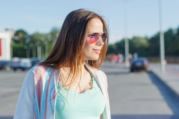 Beautiful woman on the street, side view, blurred background