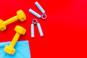 Fitness background with sport equipment for gym and home on red background top view copyspace