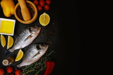Fish seafood dorado cooking, raw food on black background,  bream.