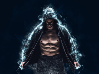 Brutal strong athletic bodybuilder posing. Electric power explosion from muscles after workout. Bodybuilding and healty life concept. Copy space for sport nutrition ads