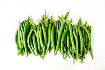 Green beans on white wooden background. Top view.