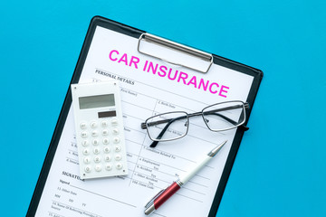 Car insurance form near glasses, calculator, pen on blue background top view