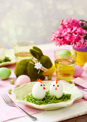 Funny chickens from eggs on the Easter table. Easter table setting