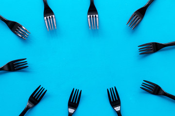 preparing food concept for restaurant menu with plastic forks frame on blue background top view