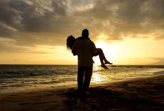 silhouette of couple on the beach at sunset