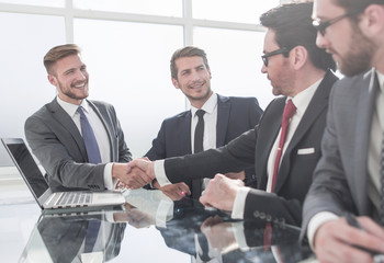 handshake financial partners over the negotiating table.