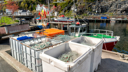 Fishing nets, colorful buoys on the quay of the Norwegian marina.