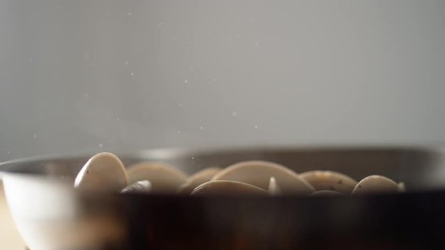 Camera follows adding pasta on cooked clams in a pan. Shot with high speed camera, phantom flex 4K. Slow Motion.