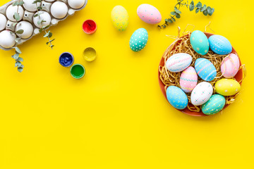 paint eggs for Easter celebration on yellow background top view mock up