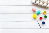 eggs with colorful paint for easter tradition on white wooden background top view mockup