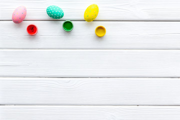 eggs with colorful paint for easter tradition on white wooden background top view mockup