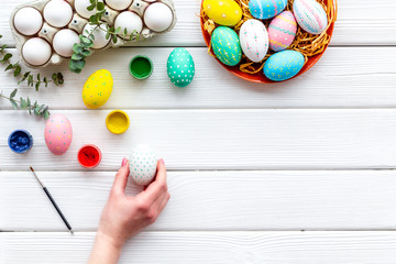 eggs with colorful paint for easter tradition on white wooden background top view mockup