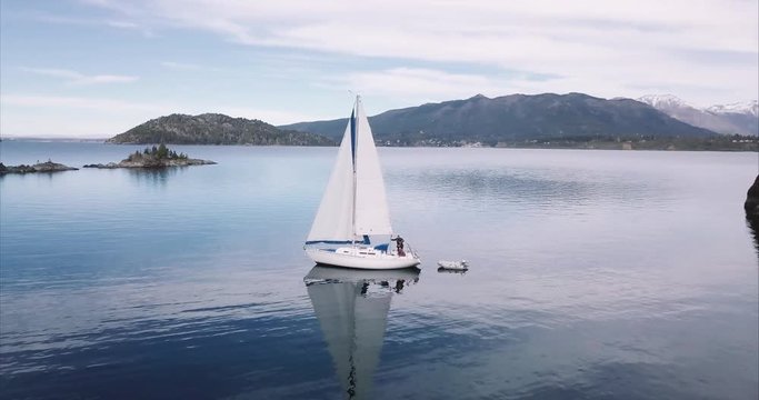 Yacht sailing surrounding an island. Aerial view of the national park Nahuel Huapi, Bariloche, Argentina. 4k