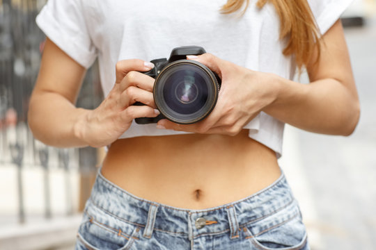 Take a snap. Cropped horizontal close up shot of a young woman holding a camera going to take a picture