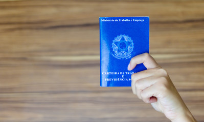 Hands of a worker holding a portfolio of Brazilian workers (Translation 