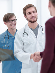 smiling doctor shaking hand of a patient