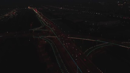 Aerial top view of highway interchange at night. Aerial top view of road junction from above, automobile traffic and jam of many cars, useful for engineering, industrial, transportation concept