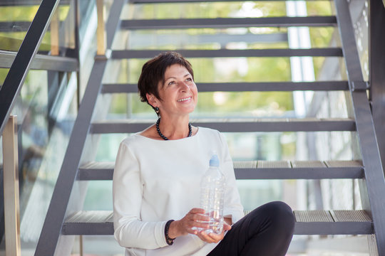 Content mature woman with bottle of water