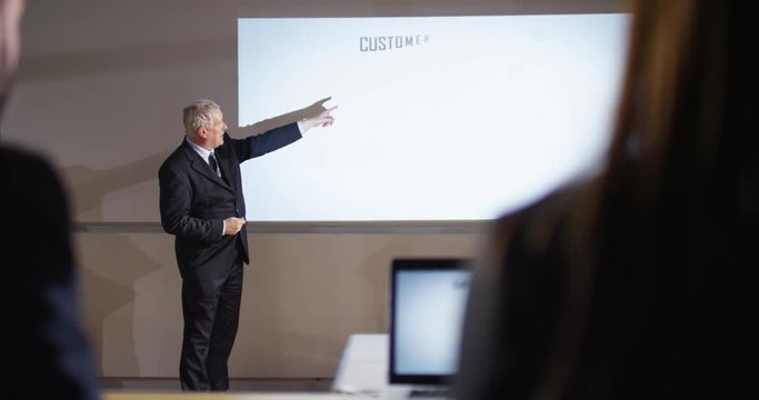 4K Mature businessman presenting marketing data analysis in a meeting. Slow motion.