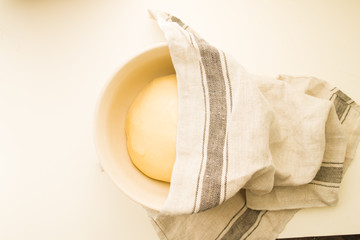 Step by step recipe to prepare a tasty challah, ingredients list  500 grams of baking wheat on a big  porcela jar, top view over a yellow background, check the ther image of the series.