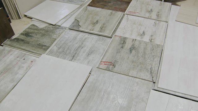 broken and bad painted ceramic tiles are lying on floor in warehouse, panoramic view