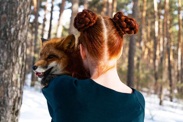 redhead girl in the forest with a fox