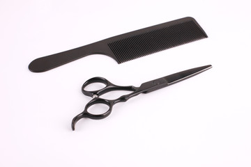 Barber scissors and a hairbrush isolated on white background